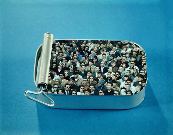 UNITED STATES - CIRCA 1960s:  Crowd of men and women packed inside open sardine tin.  (Photo by H. Armstrong Roberts/Retrofile/Getty Images)
